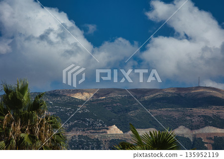 A sweeping mountain landscape in August 2025, with tiered, wooded hills under a clear summer sky. 135952119