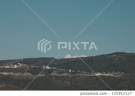 A sweeping mountain landscape in August 2025, with tiered, wooded hills under a clear summer sky. A sweeping mountain landscape in August 2025, with tiered, wooded hills under a clear summer sky. 135952127