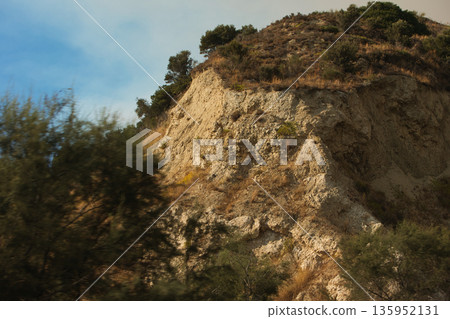 A sweeping mountain landscape in August 2025, with tiered, wooded hills under a clear summer sky. A sweeping mountain landscape in August 2025, with tiered, wooded hills under a clear summer sky. 135952131