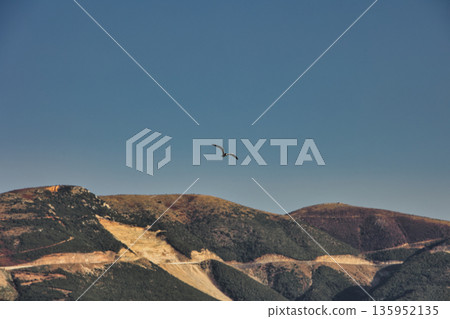 A sweeping mountain landscape in August 2025, with tiered, wooded hills under a clear summer sky. A sweeping mountain landscape in August 2025, with tiered, wooded hills under a clear summer sky. 135952135