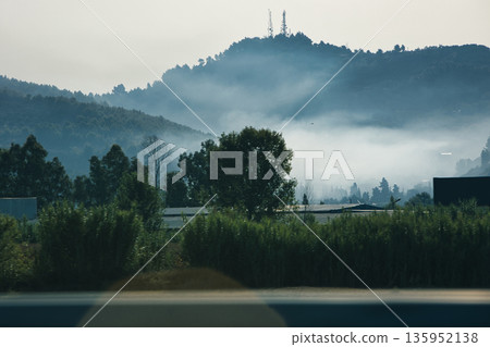 A sweeping mountain landscape in August 2025, with tiered, wooded hills under a clear summer sky. A sweeping mountain landscape in August 2025, with tiered, wooded hills under a clear summer sky. 135952138
