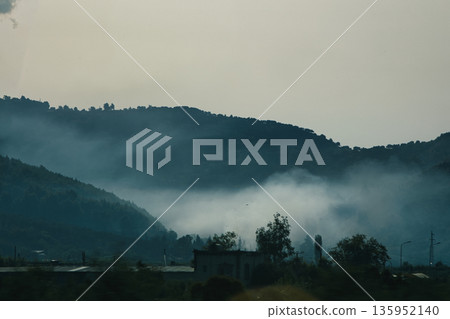 A sweeping mountain landscape in August 2025, with tiered, wooded hills under a clear summer sky. A sweeping mountain landscape in August 2025, with tiered, wooded hills under a clear summer sky. 135952140