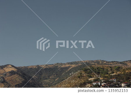 A sweeping mountain landscape in August 2025, with tiered, wooded hills under a clear summer sky. A sweeping mountain landscape in August 2025, with tiered, wooded hills under a clear summer sky. 135952153