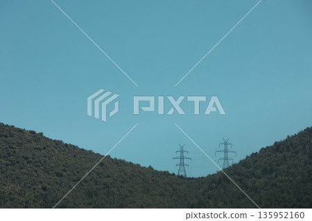 A sweeping mountain landscape in August 2025, with tiered, wooded hills under a clear summer sky. A sweeping mountain landscape in August 2025, with tiered, wooded hills under a clear summer sky. 135952160