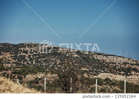 A sweeping mountain landscape in August 2025, with tiered, wooded hills under a clear summer sky. A sweeping mountain landscape in August 2025, with tiered, wooded hills under a clear summer sky. 135952164