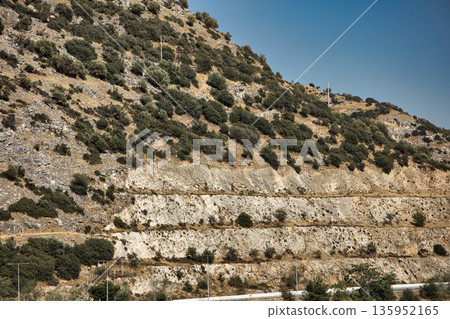 A sweeping mountain landscape in August 2025, with tiered, wooded hills under a clear summer sky. A sweeping mountain landscape in August 2025, with tiered, wooded hills under a clear summer sky. 135952165