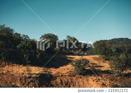 A sweeping mountain landscape in August 2025, with tiered, wooded hills under a clear summer sky. A sweeping mountain landscape in August 2025, with tiered, wooded hills under a clear summer sky. 135952172