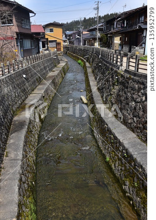 Old townscape of Takayama City, Gifu Prefecture, Japan. Old houses exuding a sense of history. Morning scene during the Takayama Spring Festival. A stream running through the city. Old townscape of Takayama City, Gifu Prefecture, Japan. Old houses exuding a sense of history. Morning scene during the Takayama Spring Festival. A stream running through the city. 135952799