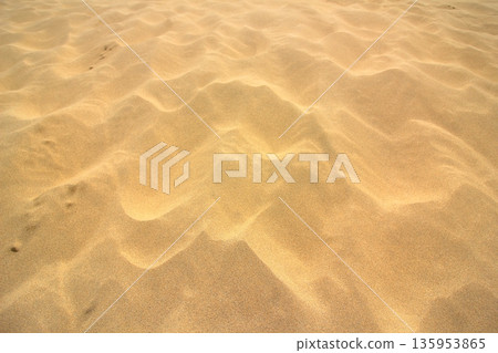 風在光滑的沙灘上泛起漣漪。 風在光滑的沙灘上泛起漣漪。 135953865