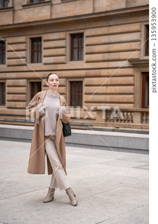 Young beautiful woman wearing coat walking in the city centre of Prague, Europe Young beautiful woman wearing coat walking in the city centre of Prague, Europe 135953900
