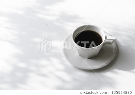 白色背景上的咖啡杯，陽光透過樹木投射的陰影，以及大量的留白。 135954880