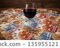 Red wine glass on a pile of euro banknotes during a wine sale event 135955121