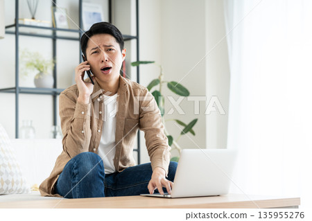 Middle man using a computer in the living room 135955276
