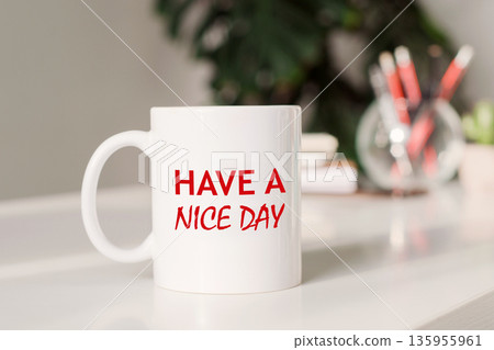 Coffee mug with text HAVE A NICE DAY in workplace background. Coffee mug with text HAVE A NICE DAY in workplace background. 135955961