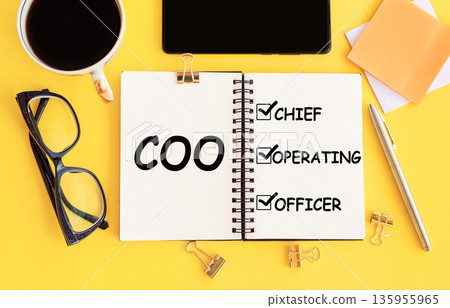 COO - acronym (Chief Operating Officer) with text on notepad and office accessories on yellow desk. COO - acronym (Chief Operating Officer) with text on notepad and office accessories on yellow desk. 135955965
