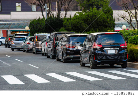 A line of cars waiting for a family at the rotary in front of the station in the evening 135955982