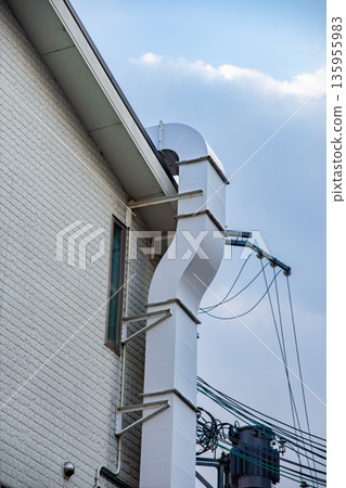 Exhaust duct attached to the exterior wall of a store Exhaust duct attached to the exterior wall of a store 135955983