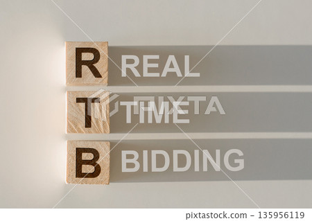 RTB - short for Real Time Bidding in wooden alphabet letters with text on shadows on light gray background. 135956119