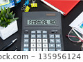 The text FINANCIAL AID written on calculator display on office table. 135956124