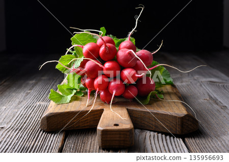 Bunch of red radishes with leaves on wooden cutting board, Bunch of red radishes with leaves on wooden cutting board, 135956693