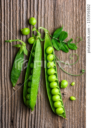 Green peas arranged on wooden surface with pods Green peas arranged on wooden surface with pods 135956802