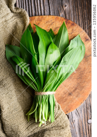 Wild garlic bundle arranged on rustic cutting board Wild garlic bundle arranged on rustic cutting board 135956862