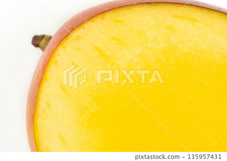 Macro texture of fresh ripe cut mango half on white background. 135957431