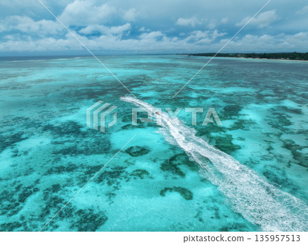 Aerial view of jet skis over shallow turquoise sea with reef Aerial view of jet skis over shallow turquoise sea with reef 135957513