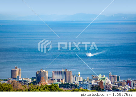 Beppu cityscape and a ferry returning to Beppu Port 135957682
