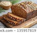 Artisan multigrain breads loaf sliced on wooden board. Freshly baked whole grain bread. Luxury healthy bakery presentation. Treat, pastry, confectionery menu, food marketing and commercial photography 135957819