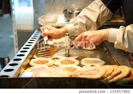 Hotteok Sweet Korean Pancake Being Cooked on a Griddle Hotteok Sweet Korean Pancake Being Cooked on a Griddle 135957860