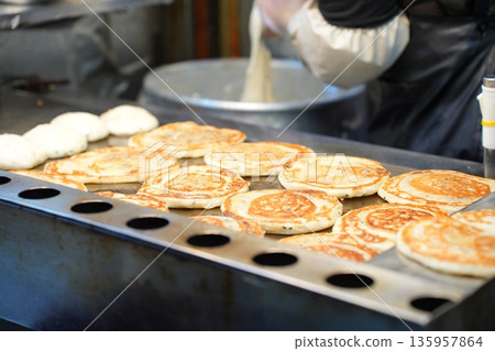 Hotteok Sweet Korean Pancake Being Cooked on a Griddle Hotteok Sweet Korean Pancake Being Cooked on a Griddle 135957864