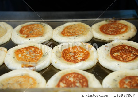 Hotteok Sweet Korean Pancake Being Cooked on a Griddle 135957867