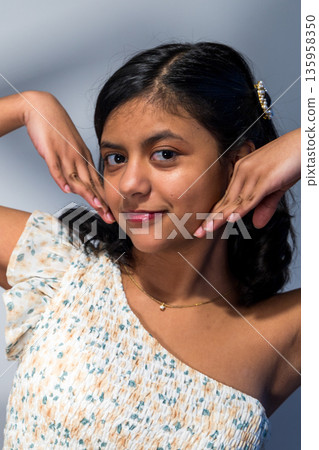 A young woman with a necklace and a flowery dress 135958350