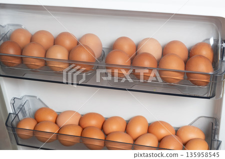 Fresh brown chicken eggs on refrigerator door shelves. Fresh brown chicken eggs on refrigerator door shelves. 135958545