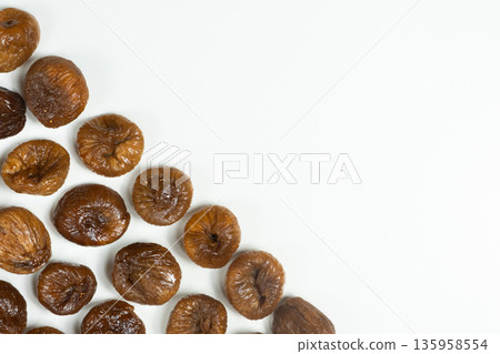 Dried figs arranged in a corner frame on a white background. 135958554