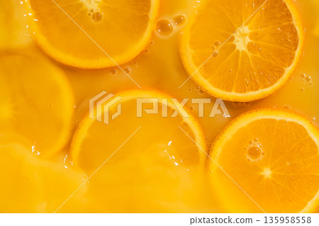 Orange slices swimming in fresh orange juice, horizontal macro. Orange slices swimming in fresh orange juice, horizontal macro. 135958558