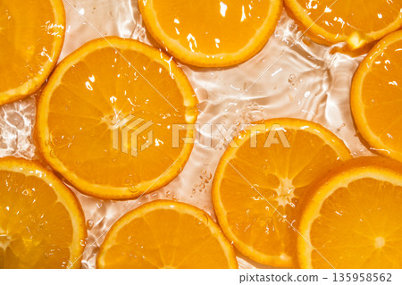 Fresh fruity background of orange slices in splash of water Fresh fruity background of orange slices in splash of water 135958562