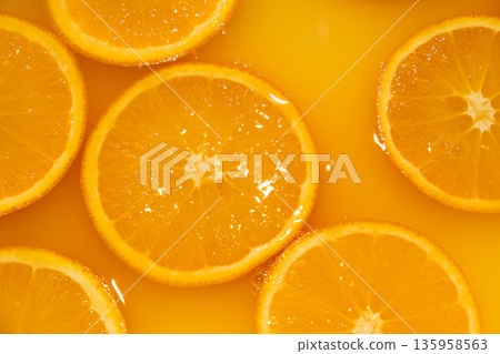Fresh slices of oranges splashing in orange juice. Fruity bright background Fresh slices of oranges splashing in orange juice. Fruity bright background 135958563