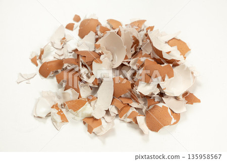 Pile of broken brown eggshell isolated on white background. Pile of broken brown eggshell isolated on white background. 135958567