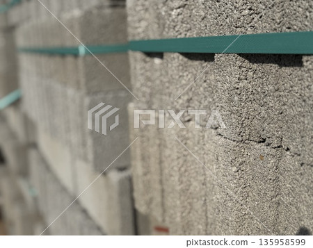 Stack of concrete blocks with green straps used in construction projects and building backgrounds Stack of concrete blocks with green straps used in construction projects and building backgrounds 135958599