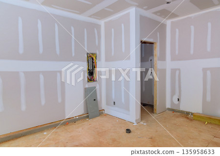 Construction is taking place in room with unfinished walls bare floors, of ongoing work preparing room 135958633