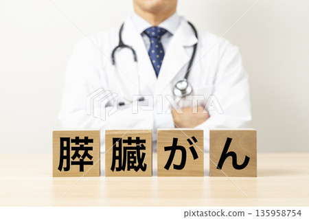 一塊寫著「胰臟癌」字樣的磚塊,旁邊還有一位醫生 一塊寫著「胰臟癌」字樣的磚塊,旁邊還有一位醫生 135958754