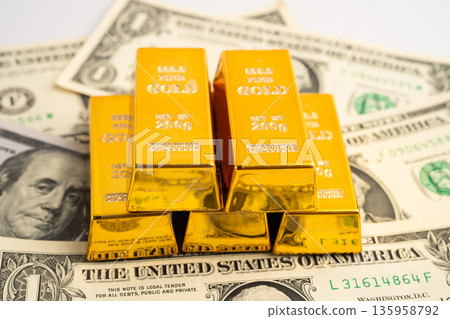 Gold bars on US dollar banknote money, finance trading investment business currency. Gold bars on US dollar banknote money, finance trading investment business currency. 135958792