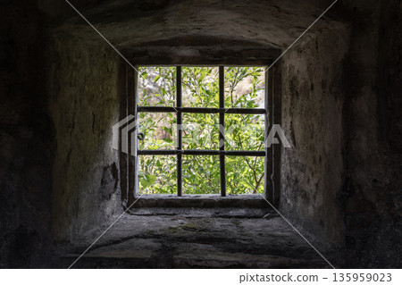 A small square window set in a rough stone wall A small square window set in a rough stone wall 135959023