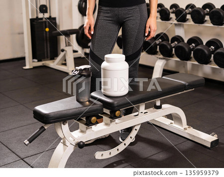 Fitness equipment and supplements on a bench in a gym, ready for a workout Fitness equipment and supplements on a bench in a gym, ready for a workout 135959379