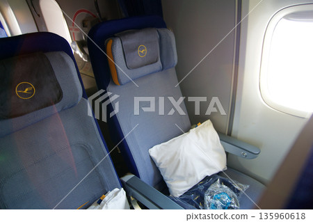 Frankfurt, Germany, 03 November 2017: Two economy class seats on board a long haul aircraft Frankfurt, Germany, 03 November 2017: Two economy class seats on board a long haul aircraft 135960618