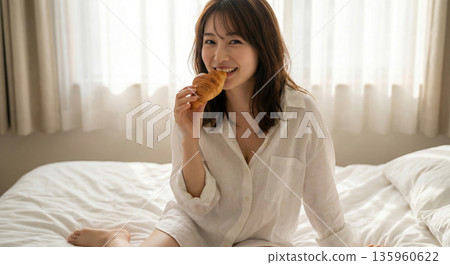 一位女子快樂地啃著麵包的肖像，清晨的景象 135960622