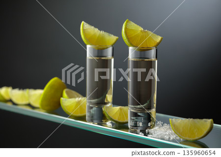 Gold tequila shots with salt and lime slices. 135960654