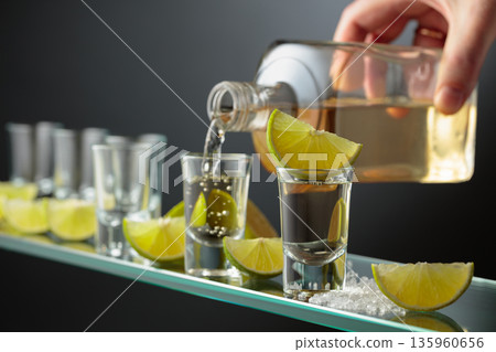 Tequila shots with salt and lime slices. 135960656